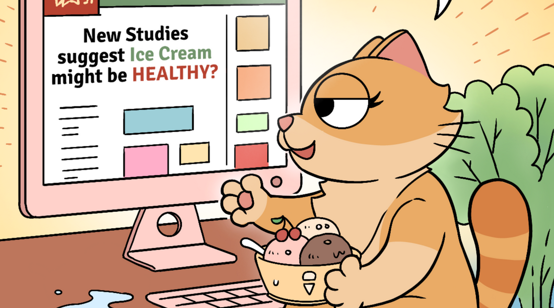 Close-up of Duchess the cat looking pleased with herself, holding a bowl of ice cream while reading "New Studies suggest Ice Cream might be HEALTHY?" on her computer screen